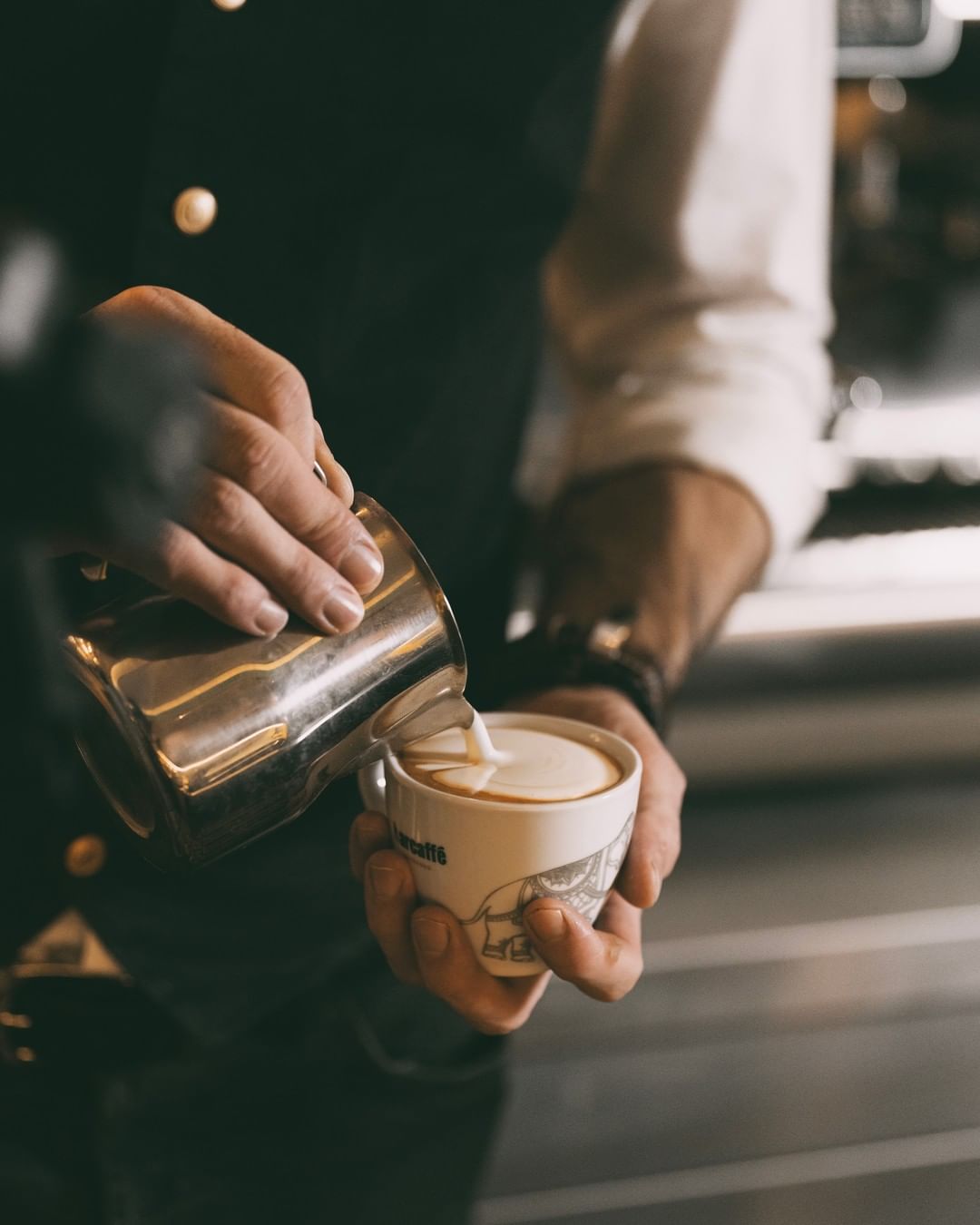 A barmen pouring a coffee, expertly - making a stunning visual